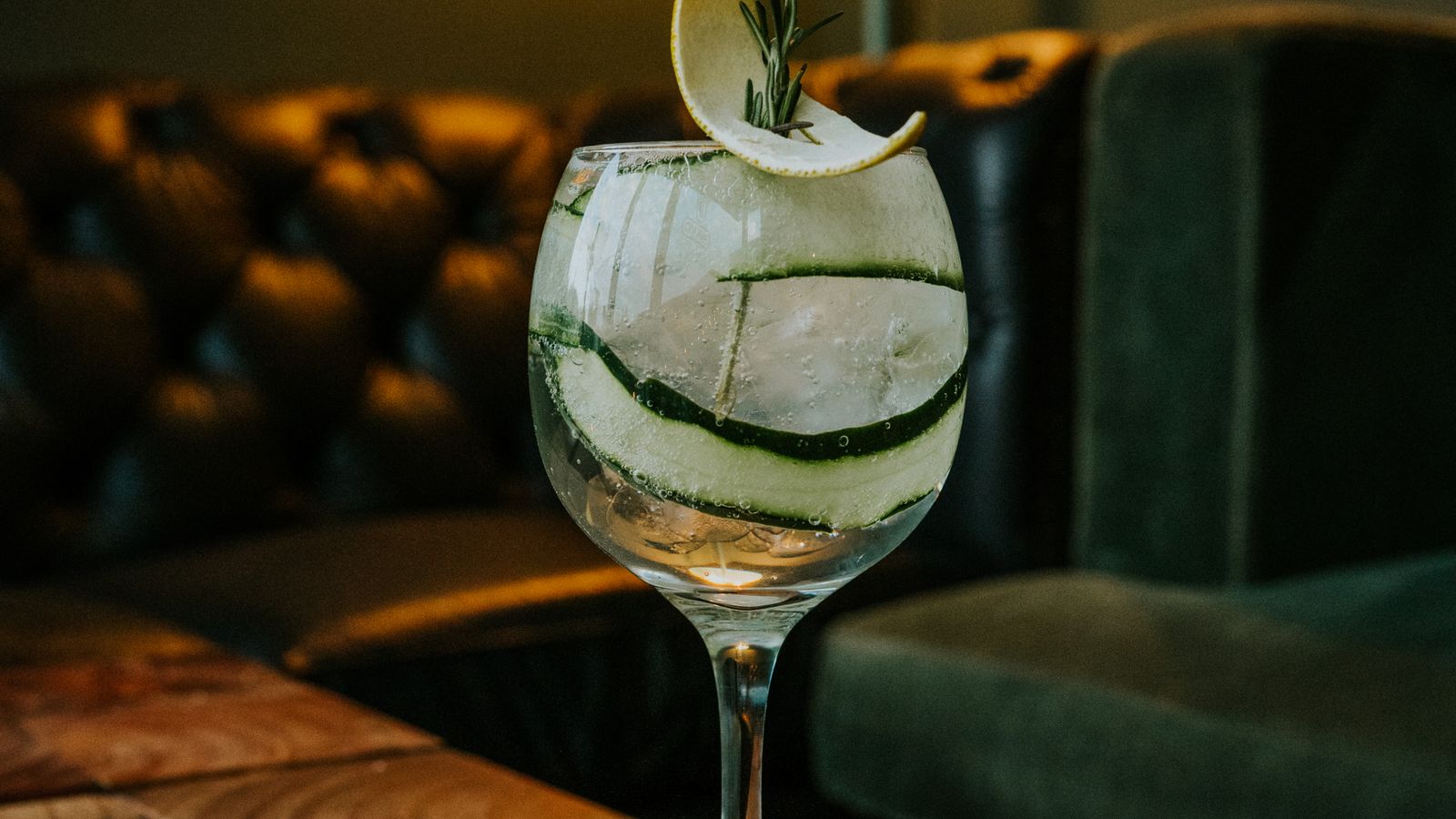 Alambique de cobre em destilaria com garrafa de gin London Dry em primeiro plano